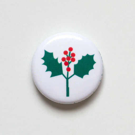 A tiny holly sprig on a 1-inch button