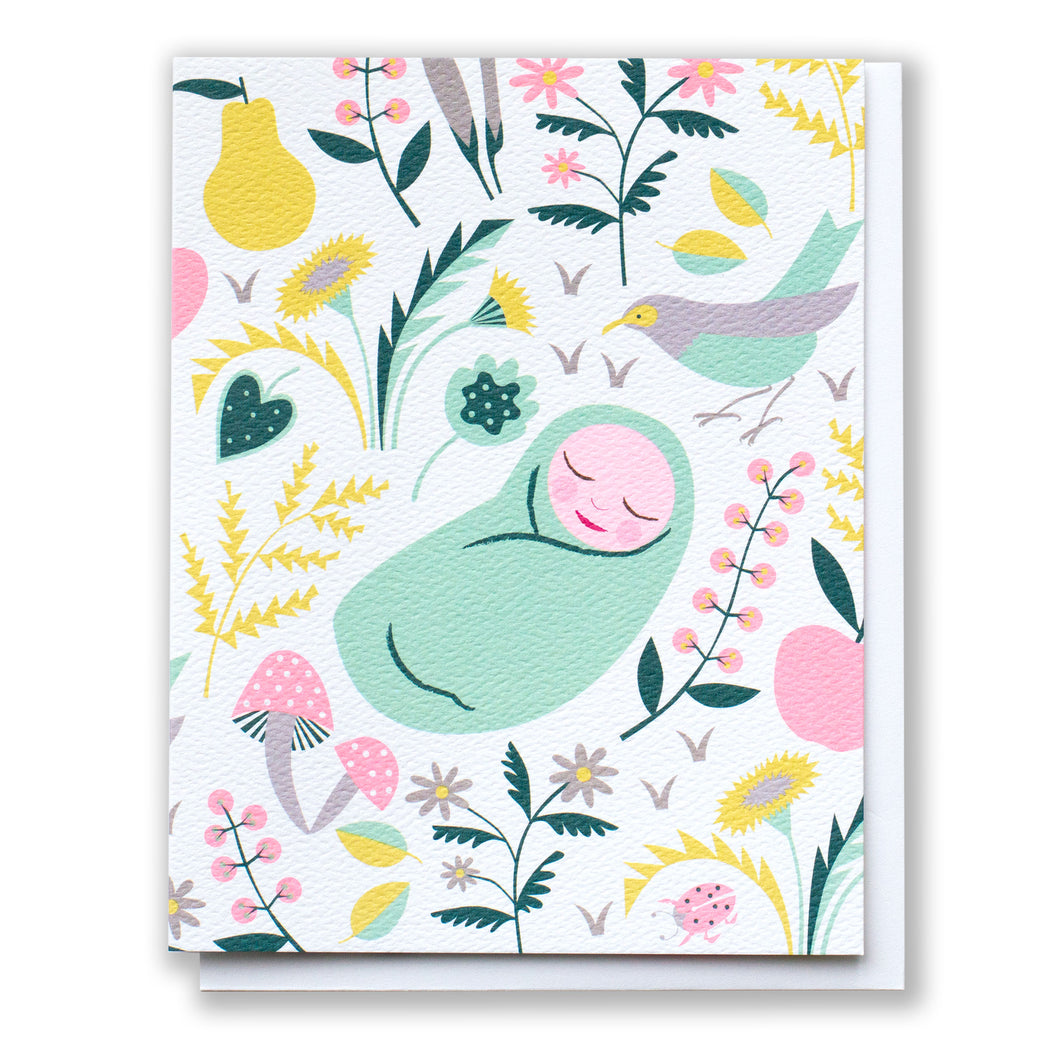 baby card with a sweet bundle of joy lying in a field of flowers
