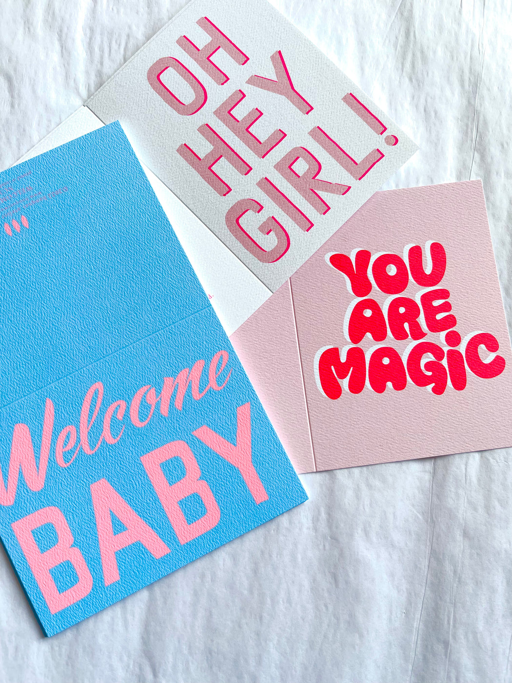 a note card with a baby pink background with a neon pink You Are Magic in bubble letter font with a Oh Hey Girl note card and Welcome Baby note card
