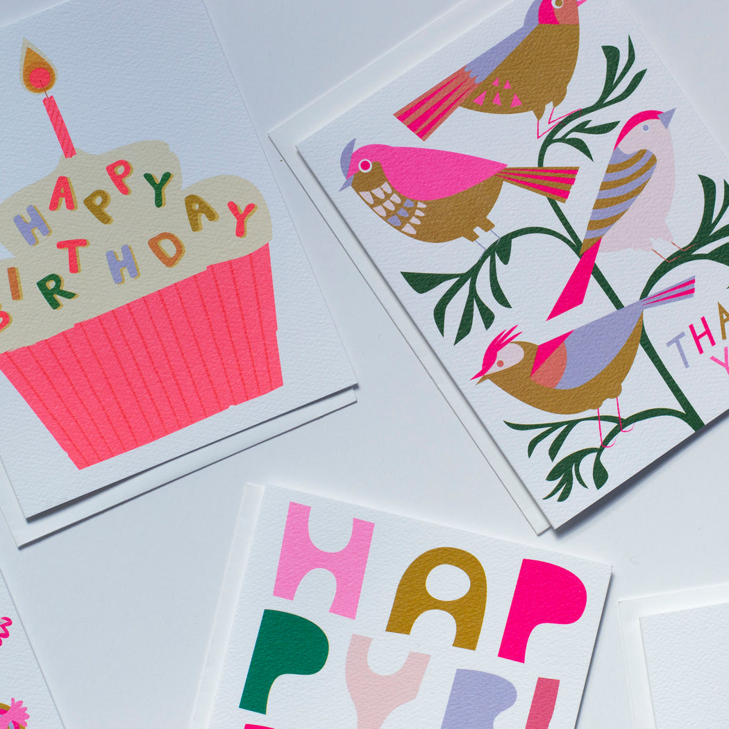 some banquet cards in neon pinks and mustard yellows with birds and cupcakes